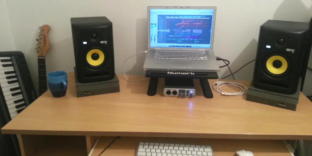 Icebreeze home studion setup comprising: macbook pro running logic studio, a pair of KRK studion monitor speakers, a Presonus audio interface. Also keyboard and guitar in background