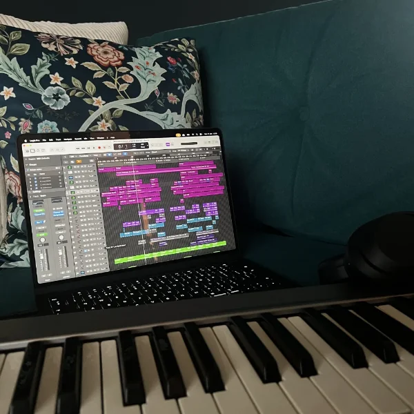 a music project in logic pro with part of a piano keyboard in the foreground in the home of Icebreeze