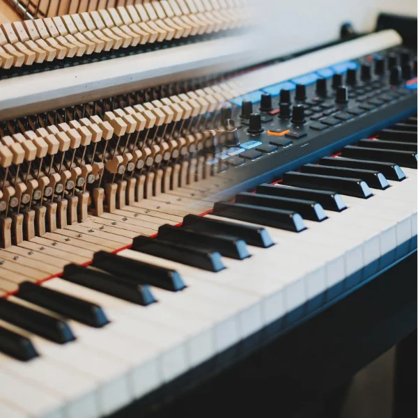composite image of traditional piano keyboard transitioning to a modern midi controller keyboard