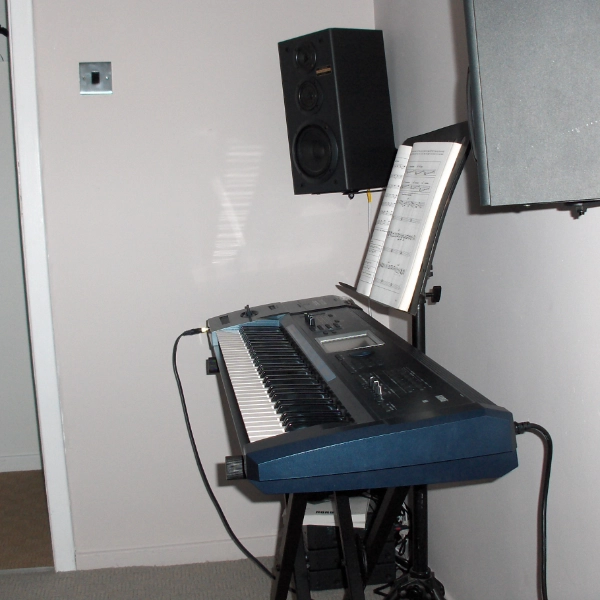 Korg Triton Extreme with music stand and speakers in room of Icebreeze